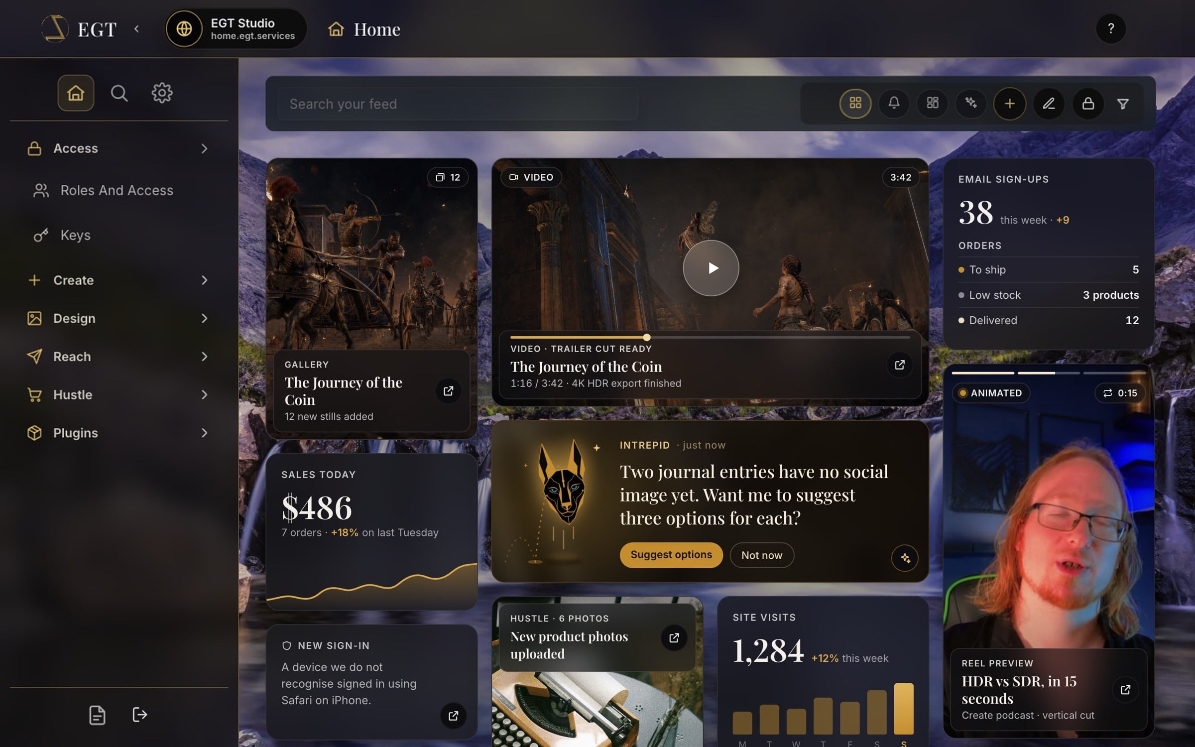 The Universe dashboard: a dark sidebar on the left, a frosted search and filter bar across the top, and a grid of rounded, frosted cards over a mountain-and-waterfall photo. The cards show a photo gallery from The Journey of the Coin, a trailer video with a play button, a vertical animated reel from the Create podcast, sales, site visits, email sign-ups and orders, product photos, a new sign-in notice, and an Intrepid card with its gold jackal mark bouncing beside a suggestion about social images.